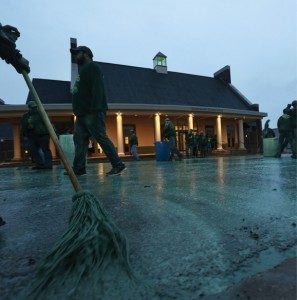 Just before dawn in front of the Hasselmann Alumni House, St. Pat’s Committee members and alumnni dressed in green holding mops paint the street green.