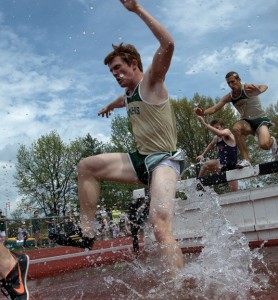 Missouri S&amp;T sophomore Garrett Wood braces himself as he enters the water while teammate Andy Naeger clears the hurdle during the men’s 3000-meter steeplechase.