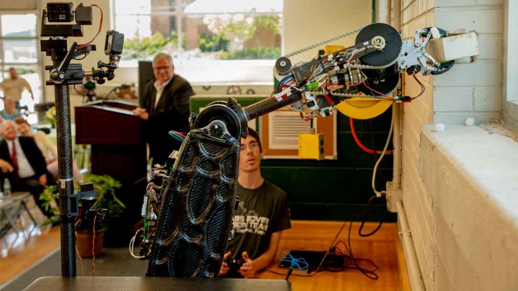 A Mars Rover Student Design Team member operates the mars rover to pull the cornerstone of the Kummer Student Design Center marking the groundbreaking of the expansion.